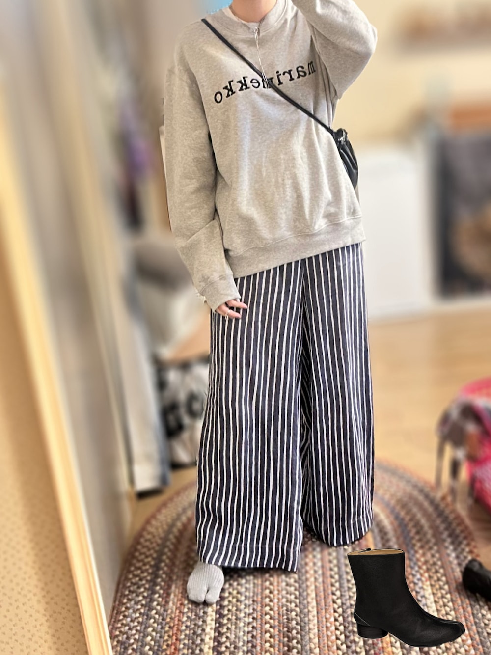 グレー系のスウェット、ブルー系のその他パンツ、ブラック系のブーツを着用したレディースの秋コーディネートの1枚目の写真