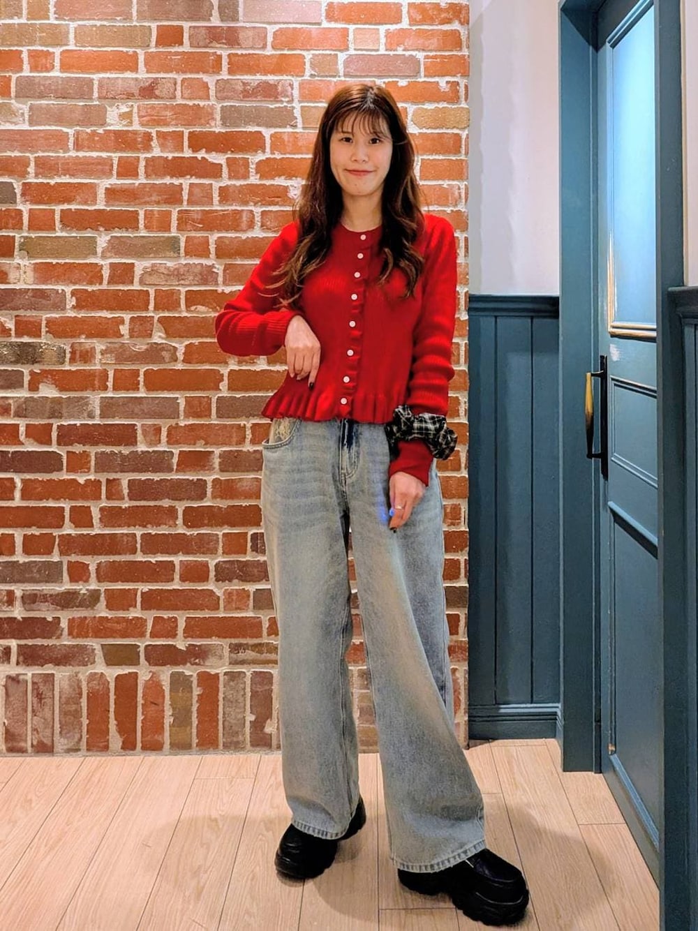 ブルー系のデニムパンツ、ブラック系のローファー、レッド系のTシャツ/カットソーを着用したレディースの冬コーディネートの1枚目の写真