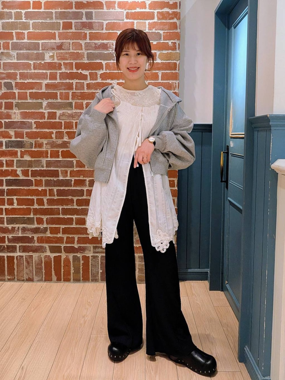 グレー系のパーカー、ブラック系のサンダル、ブラック系のその他パンツを着用したレディースの春コーディネートの1枚目の写真