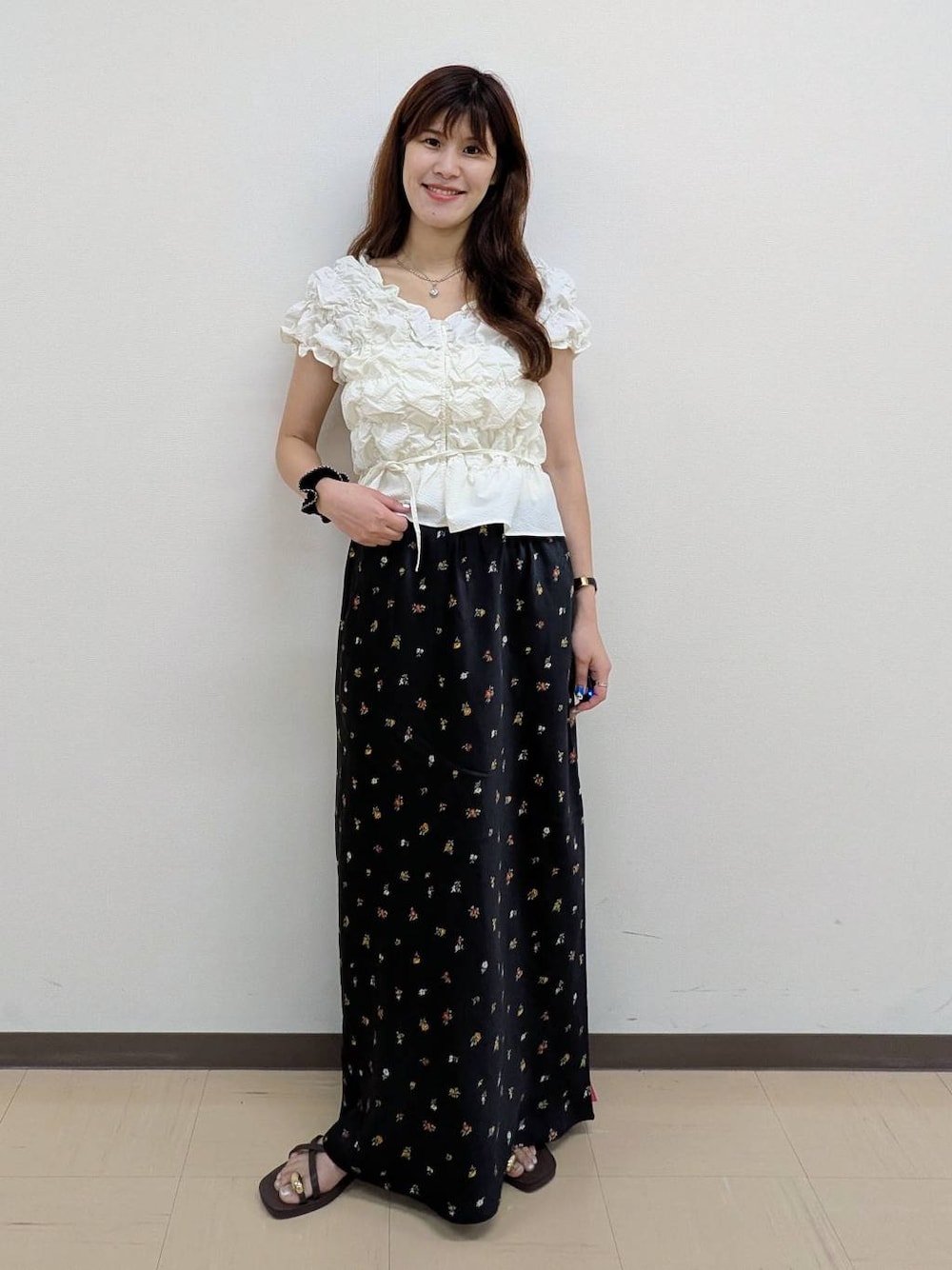 ホワイト系のシャツ/ブラウス、ブラック系のスカート、ブラウン系のサンダルを着用したレディースの夏コーディネートの1枚目の写真