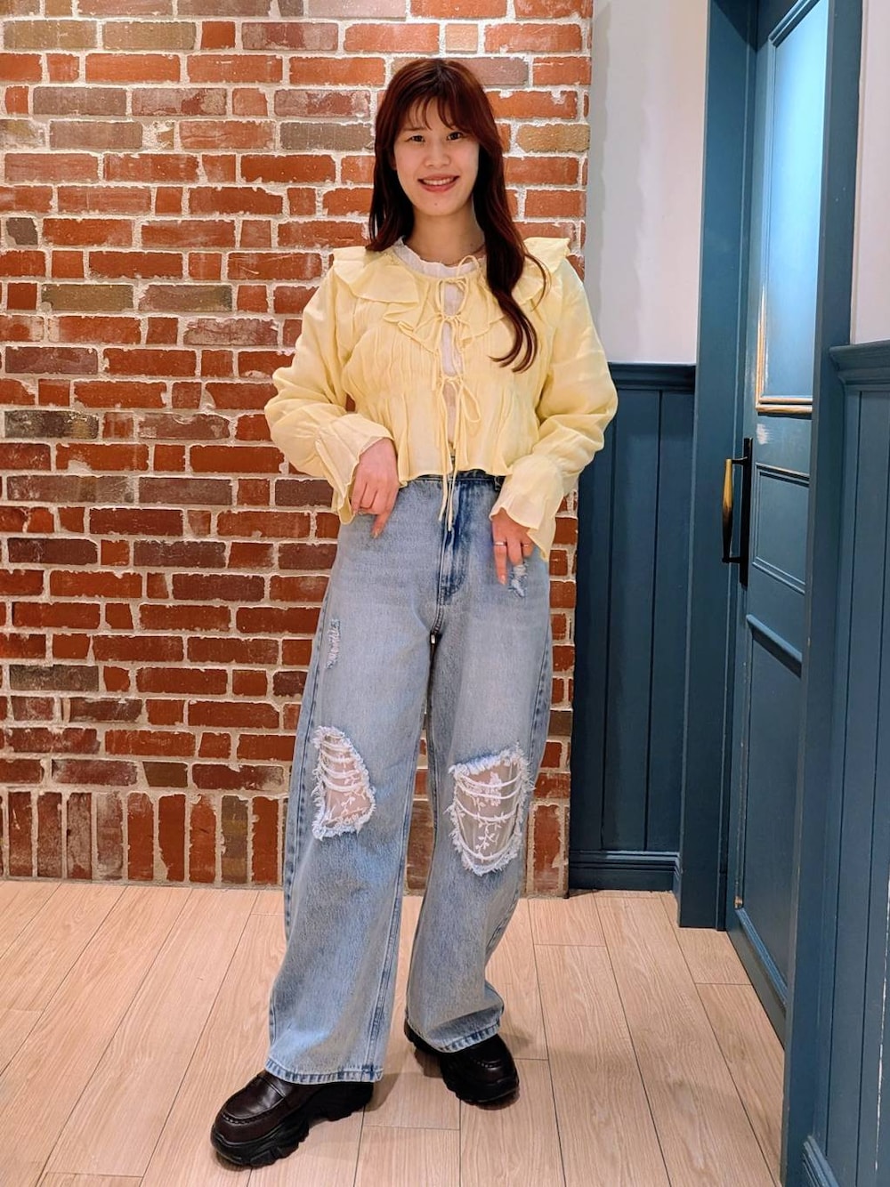 ブルー系のデニムパンツ、ブラック系のローファー、イエロー系のシャツ/ブラウスを着用したレディースの春コーディネートの1枚目の写真