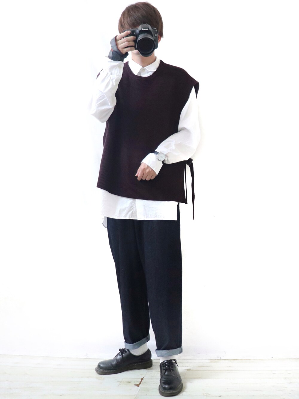 レッド系のニット/セーター、ホワイト系のシャツ/ブラウス、ブルー系のパンツを着用したメンズの秋コーディネートの1枚目の写真