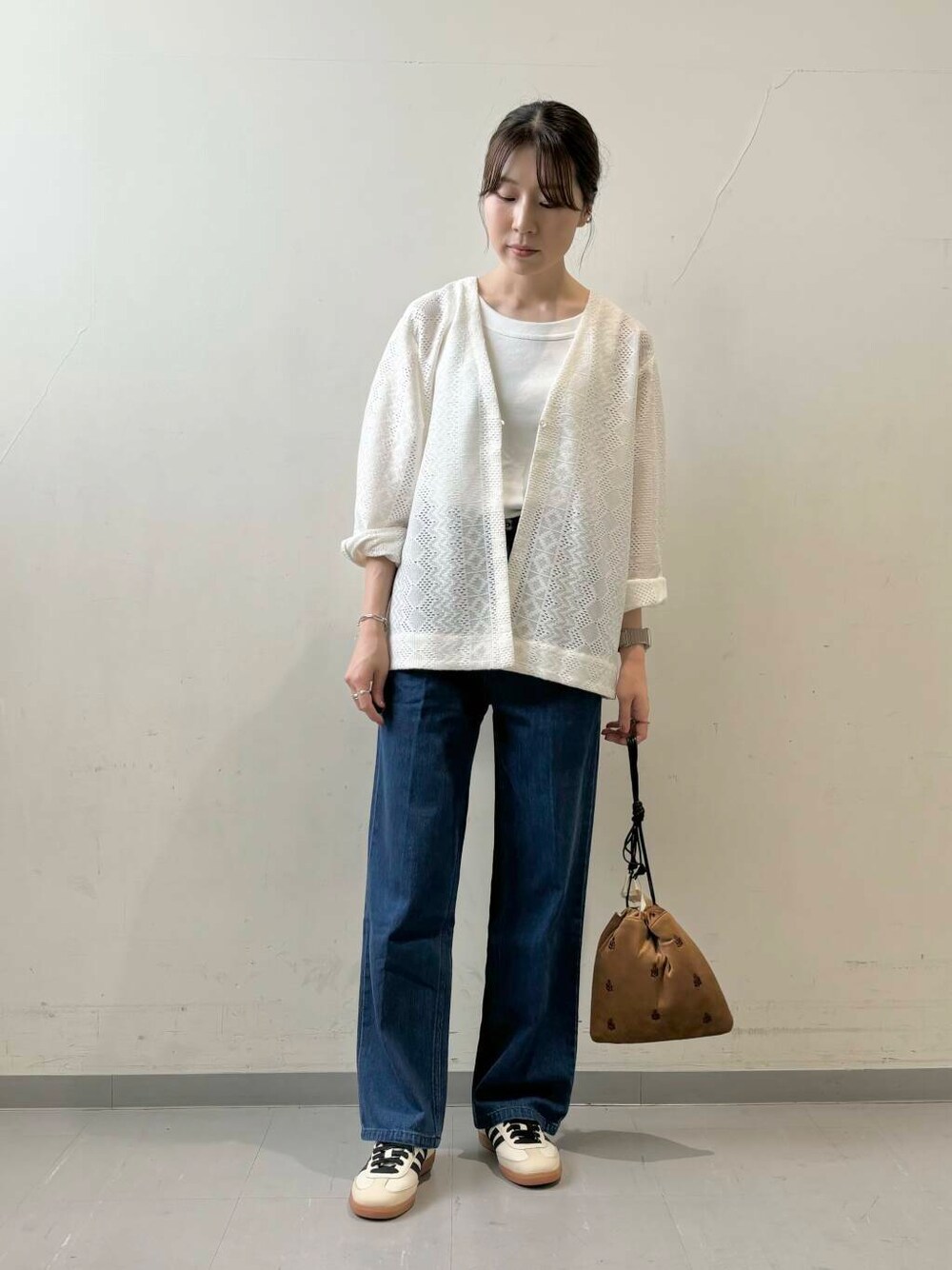 ホワイト系のタンクトップ、ブラウン系のショルダーバッグ、ベージュ系のスニーカーを着用したレディースの夏コーディネートの1枚目の写真