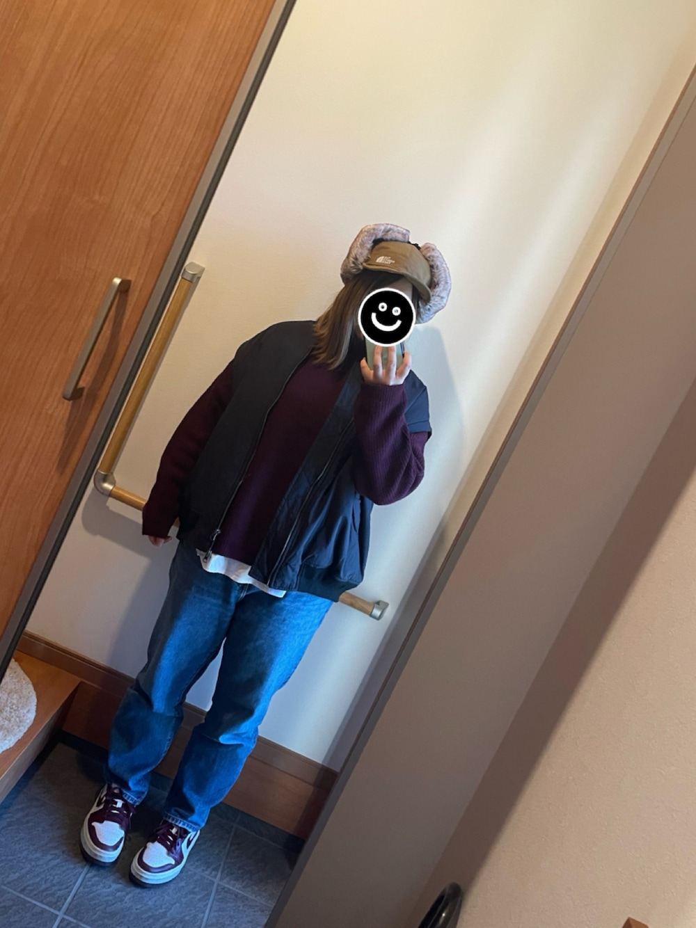 ブルー系のデニムパンツ、ホワイト系のスニーカー、レッド系のニット/セーターを着用したレディースの冬コーディネートの1枚目の写真