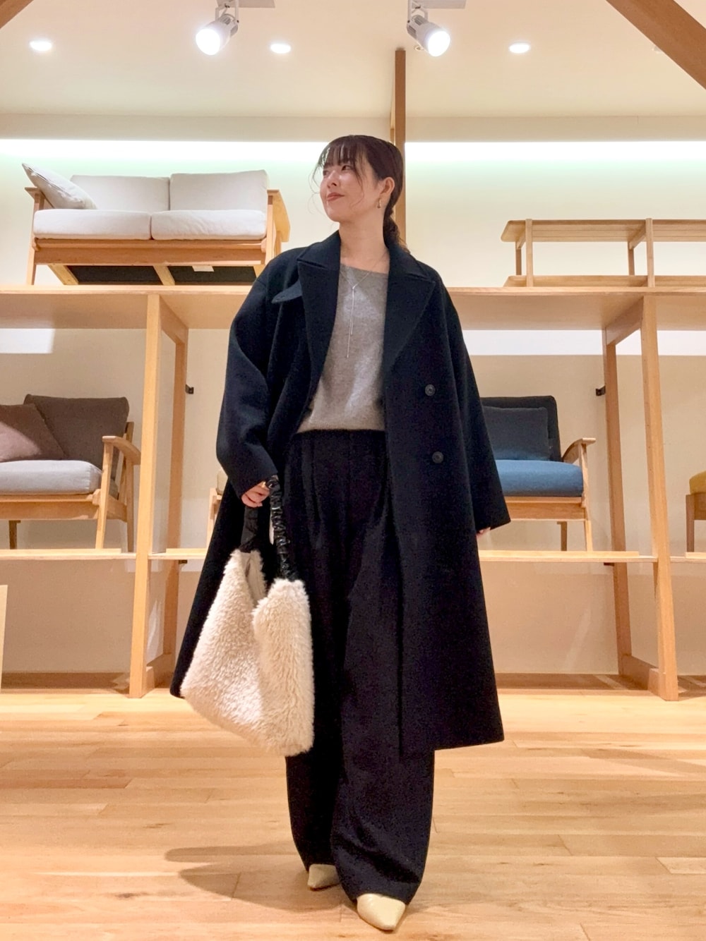 ブラック系のチェスターコート、ブラック系のその他パンツ、グレー系のニット/セーターを着用したレディースの冬コーディネートの1枚目の写真