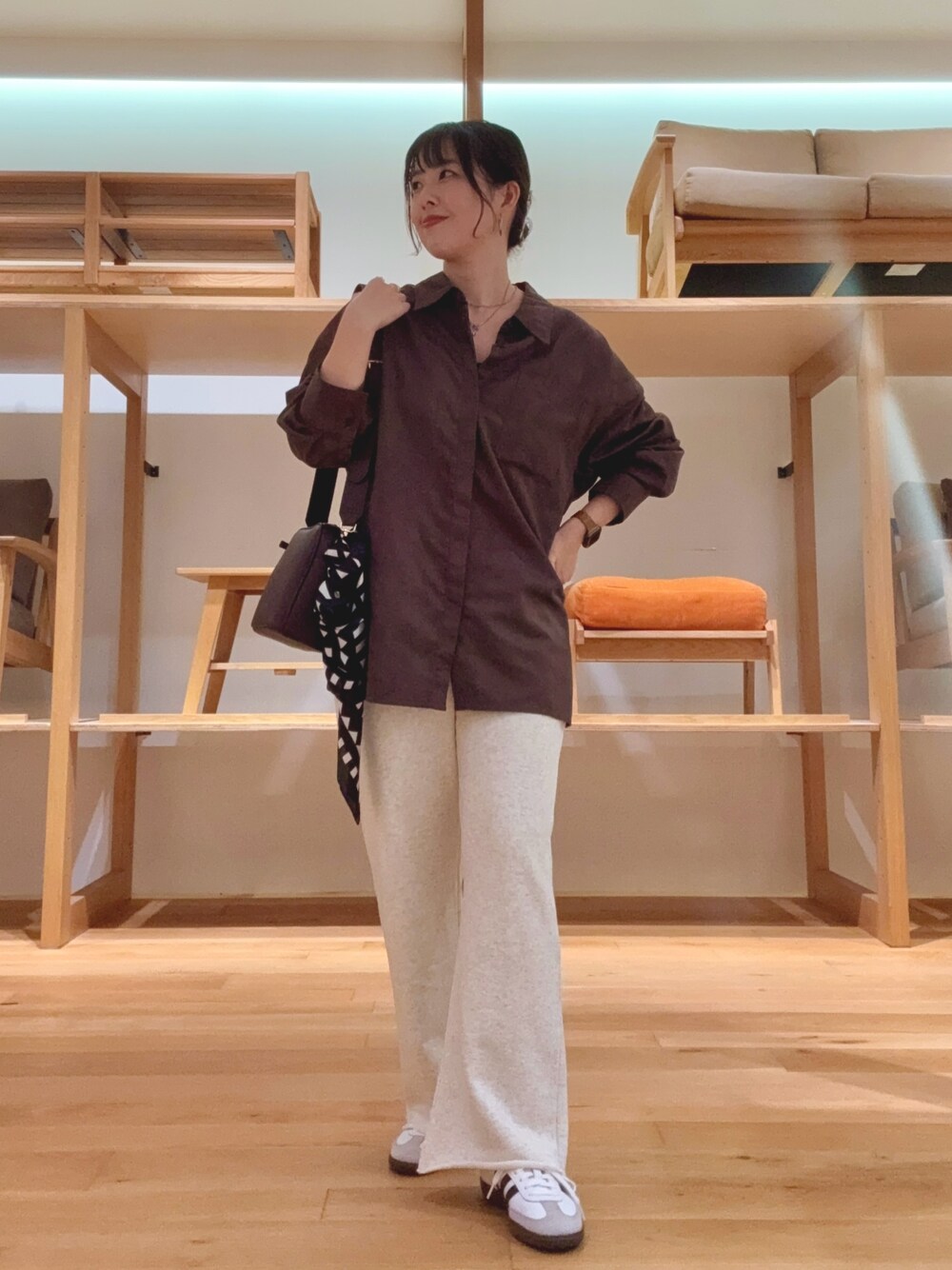 レッド系のショルダーバッグ、ブラウン系のシャツ/ブラウス、ブラック系のバンダナ/スカーフを着用したレディースの秋コーディネートの1枚目の写真