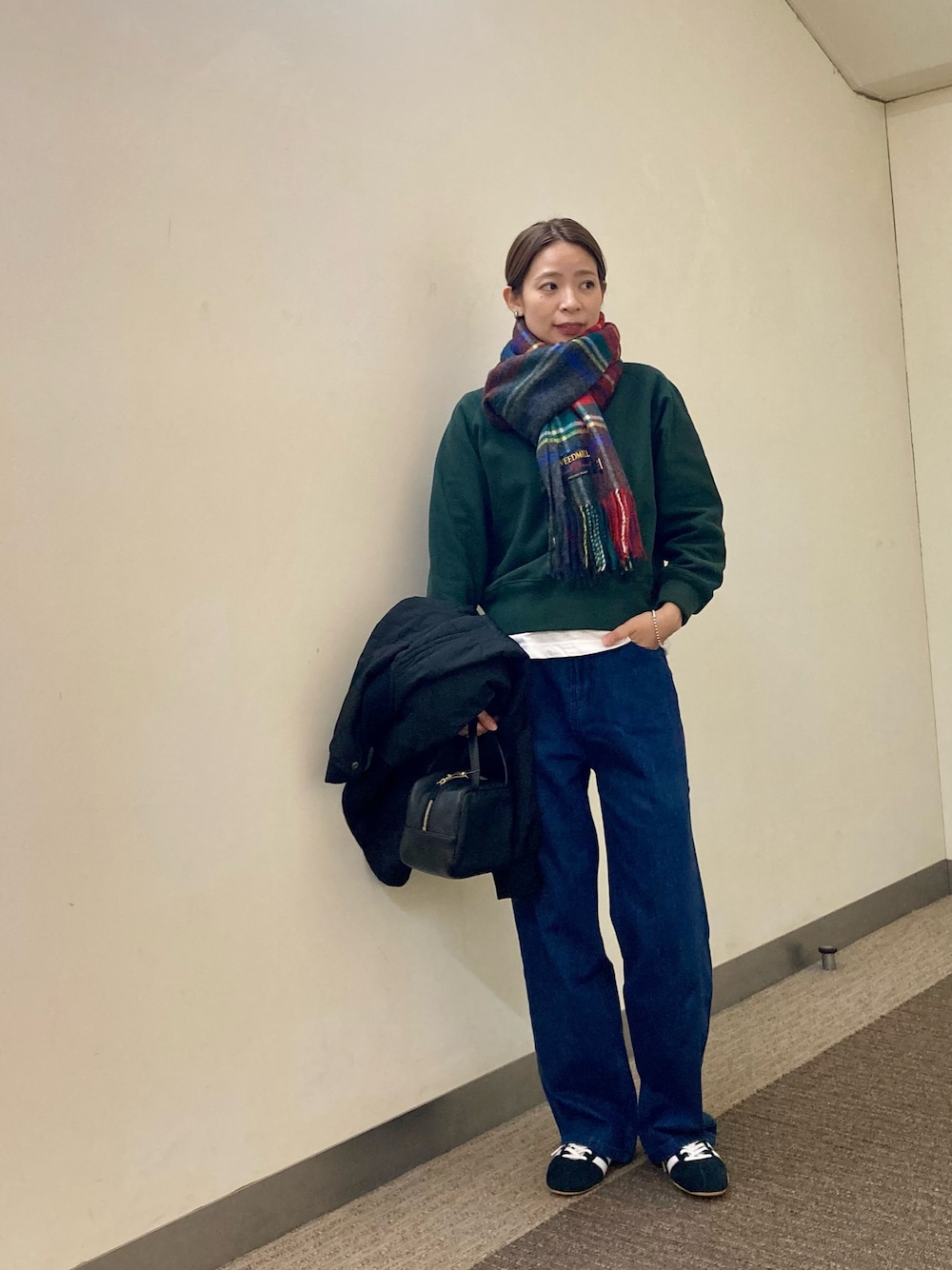 グリーン系のスウェット、ホワイト系のTシャツ/カットソー、ブルー系のデニムパンツを着用したレディースの秋コーディネートの1枚目の写真