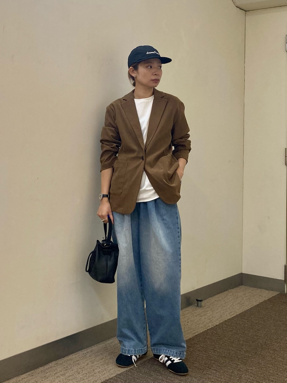 ホワイト系のTシャツ/カットソー、ベージュ系のその他アウター、ブルー系のデニムパンツを着用したレディースの秋コーディネートの1枚目の写真