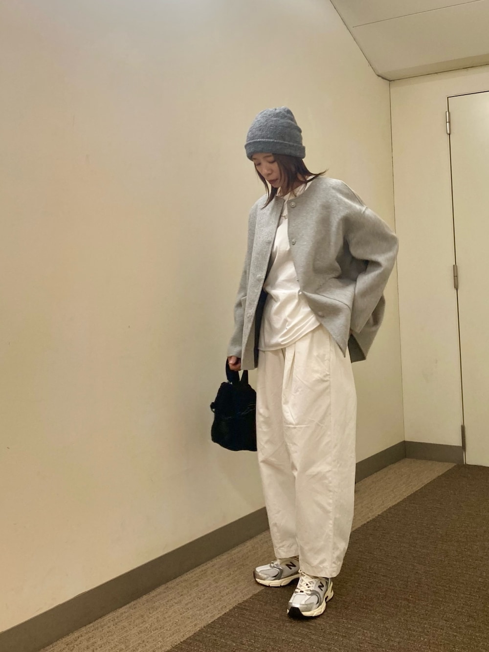 グレー系のその他アウター、ホワイト系のTシャツ/カットソー、シルバー系のスニーカーを着用したレディースの秋コーディネートの1枚目の写真