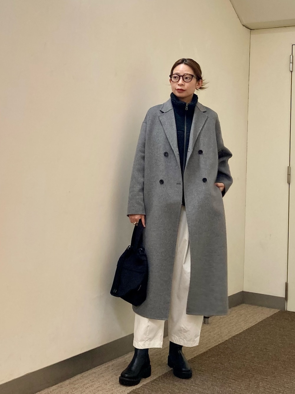 グレー系のその他アウター、グレー系のベスト、ブラック系のブーツを着用したレディースの秋コーディネートの1枚目の写真