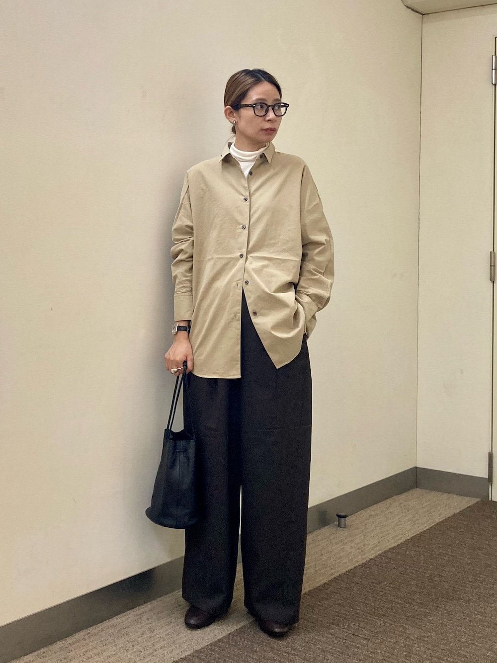 ブラウン系のパンプス、ブラック系のショルダーバッグ、ホワイト系のTシャツ/カットソーを着用したレディースの秋コーディネートの1枚目の写真