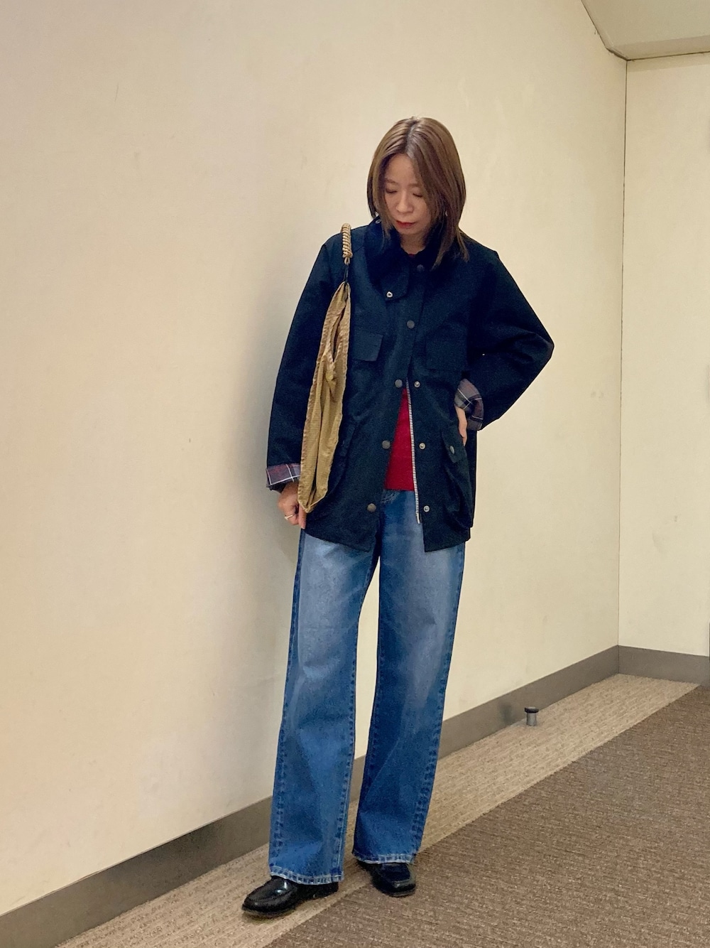 ブラック系のその他アウター、ブルー系のデニムパンツ、レッド系のニット/セーターを着用したレディースの秋コーディネートの1枚目の写真