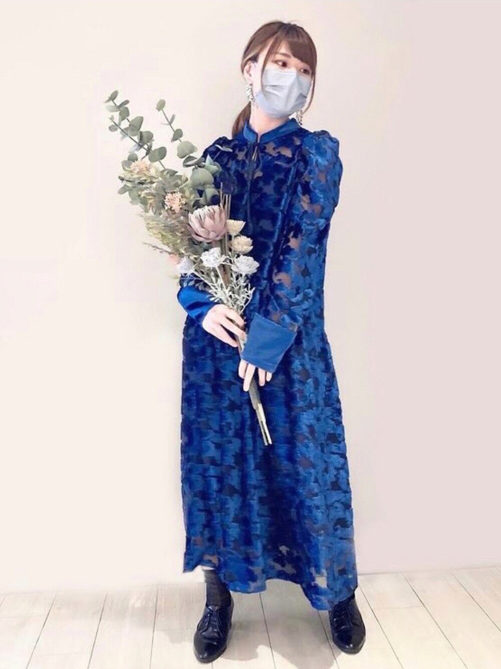 ブルー系のワンピース/ドレス、ブラック系のドレスシューズ、グレー系のイヤリングを着用したレディースの秋コーディネートの1枚目の写真