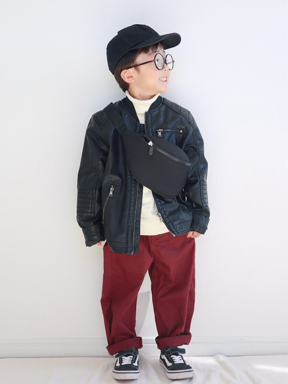 ブラック系のダウンジャケット/コート、ホワイト系のニット/セーター、レッド系のその他パンツを着用したキッズの冬コーディネートの2枚目の写真