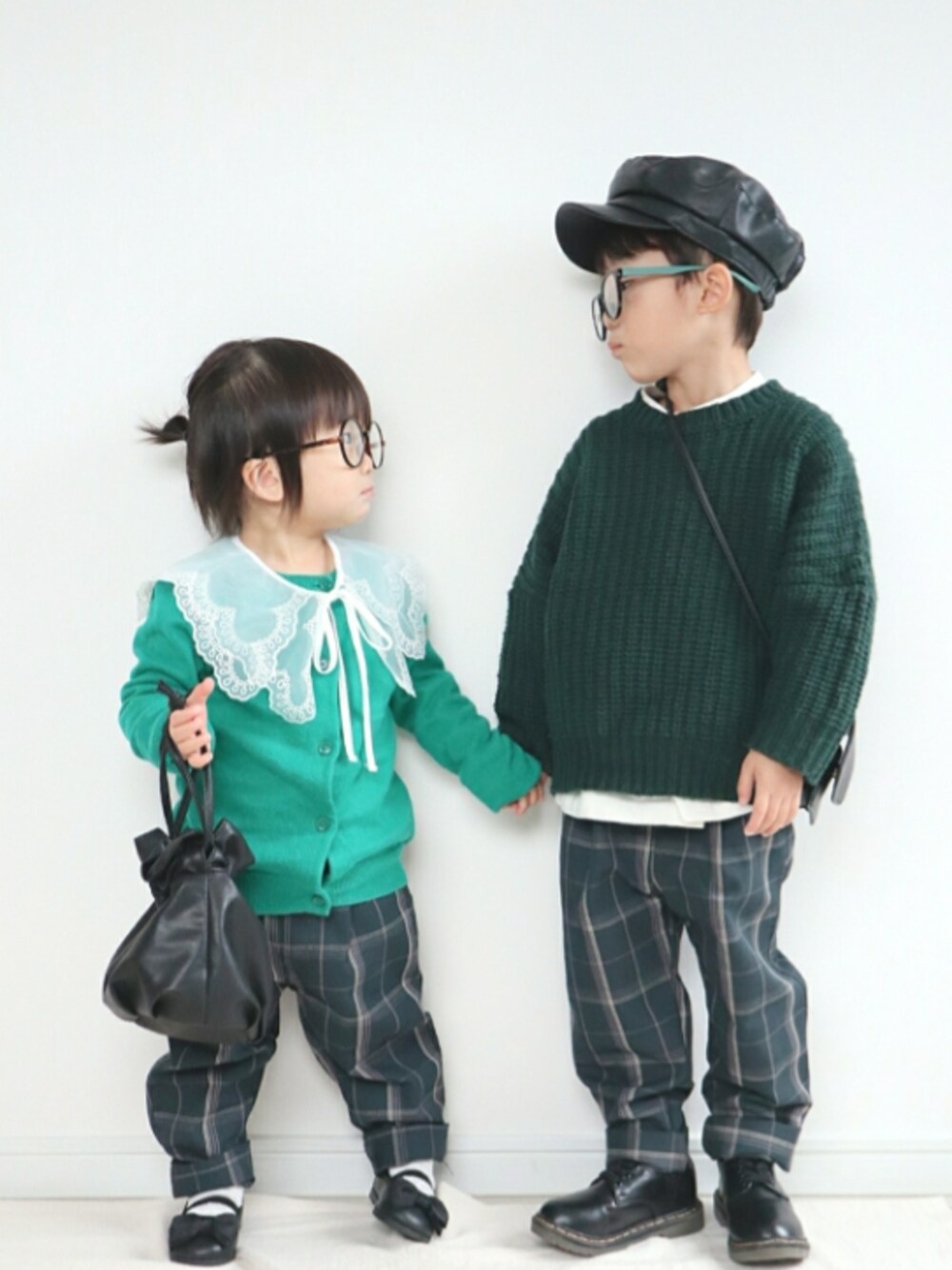 グリーン系のニット/セーター、ブラック系のローファー、グリーン系のカーディガン/ボレロを着用したキッズの冬コーディネートの1枚目の写真