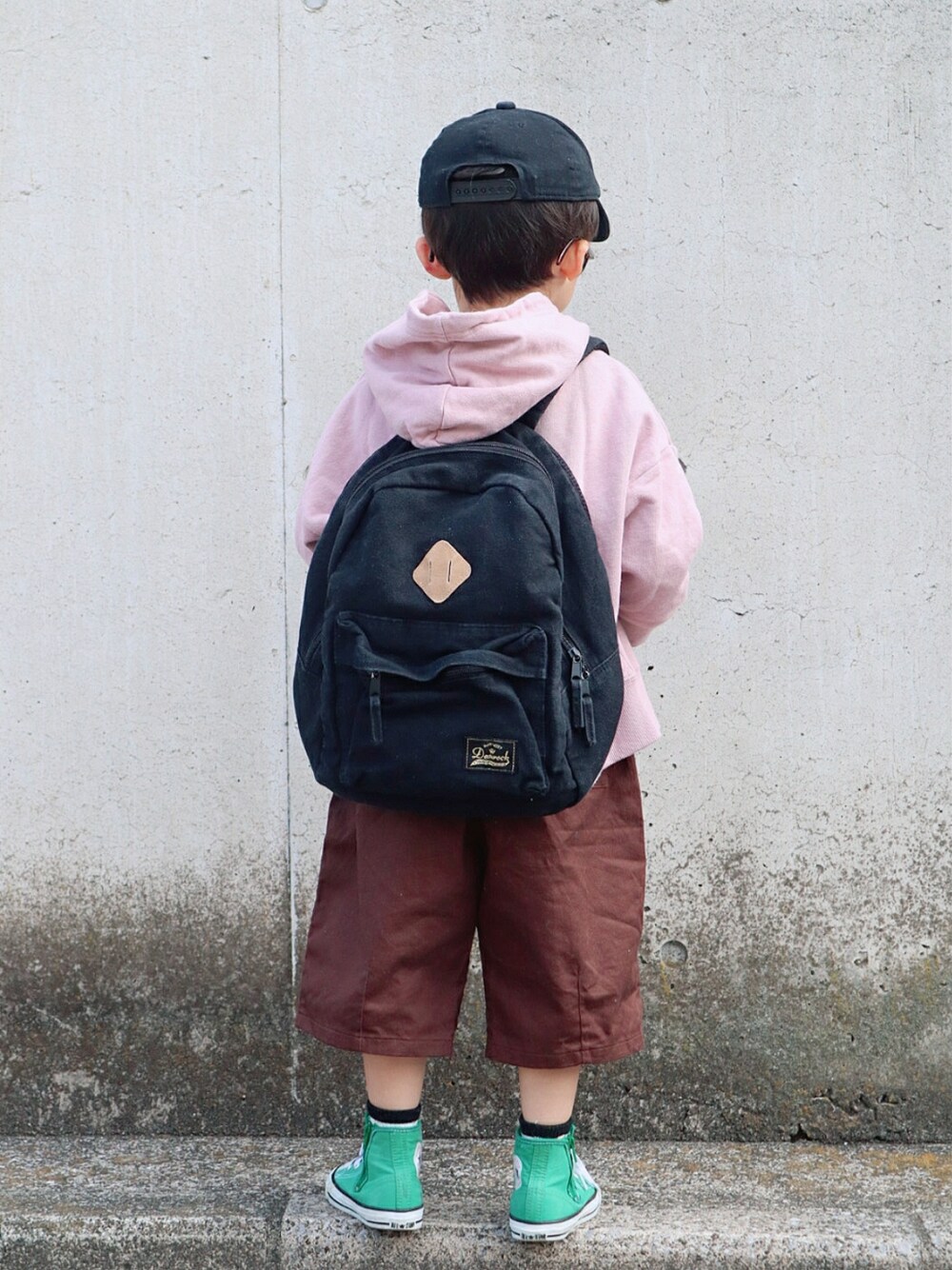 ピンク系のパーカー、ホワイト系のTシャツ/カットソー、ブラック系のバックパック/リュックを着用したキッズの冬コーディネートの3枚目の写真