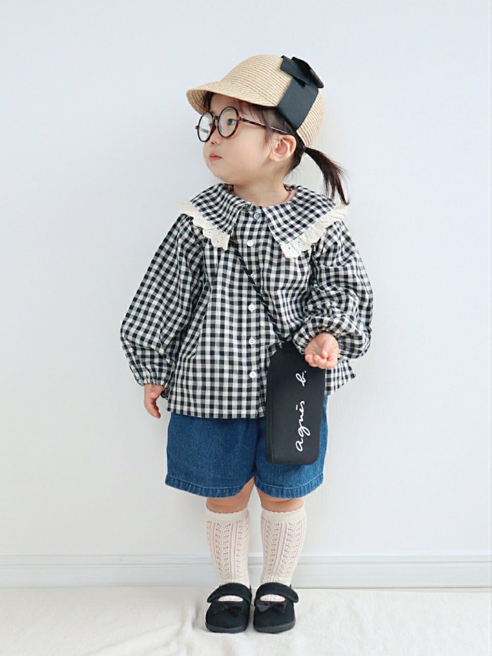 ブラック系のジャケット/アウター、ブラック系のショルダーバッグ、ブルー系のデニムパンツを着用したキッズの春コーディネートの1枚目の写真