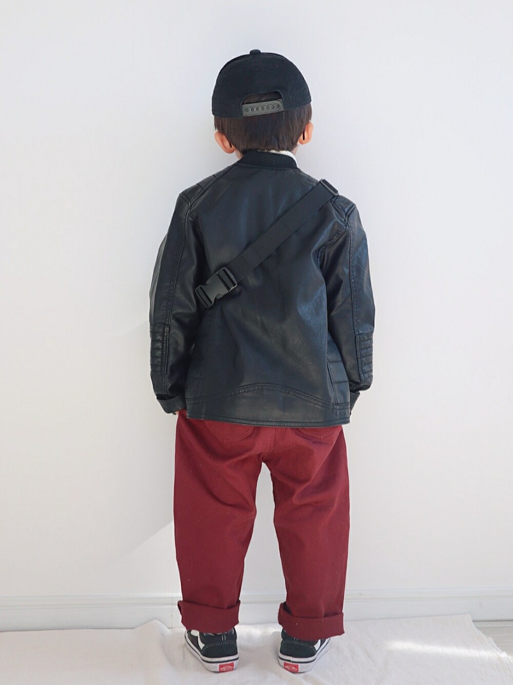 ブラック系のダウンジャケット/コート、ホワイト系のニット/セーター、レッド系のその他パンツを着用したキッズの冬コーディネートの3枚目の写真