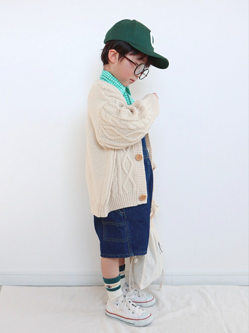 グリーン系のシャツ/ブラウス、ベージュ系のカーディガン/ボレロ、ブルー系のサロペット/オーバーオールを着用したキッズの春コーディネートの2枚目の写真