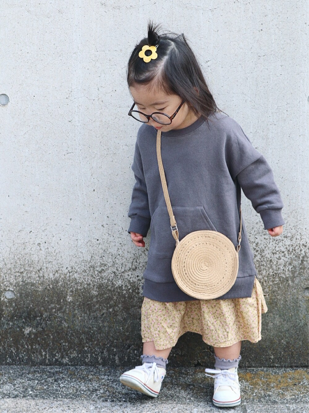 グレー系のワンピース、ベージュ系のショルダーバッグ、ホワイト系のスニーカーを着用したキッズの春コーディネートの1枚目の写真