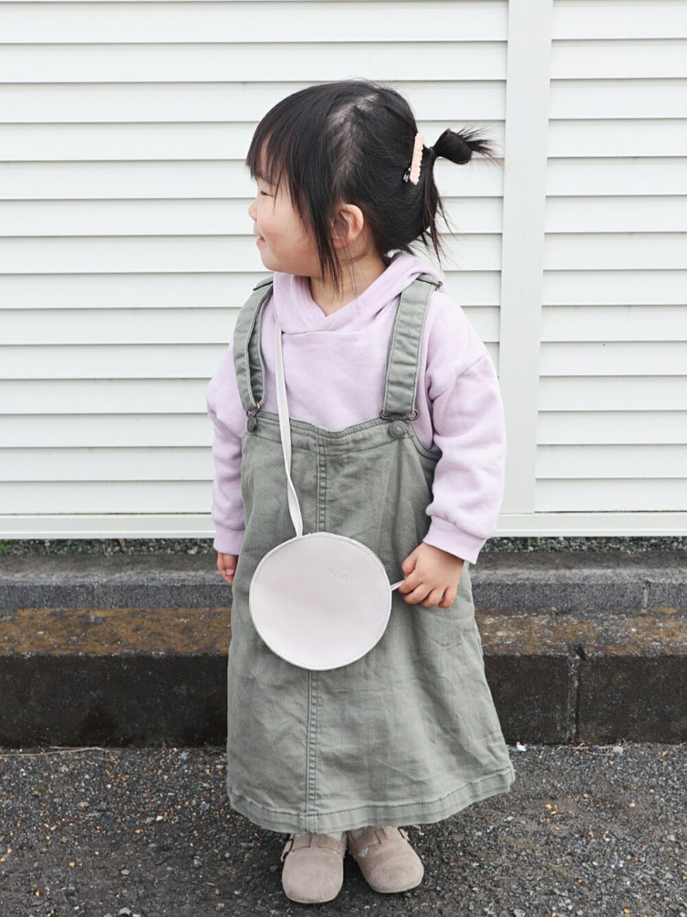 パープル系のパーカー、ベージュ系のシューズ、グリーン系のスカートを着用したキッズの春コーディネートの2枚目の写真