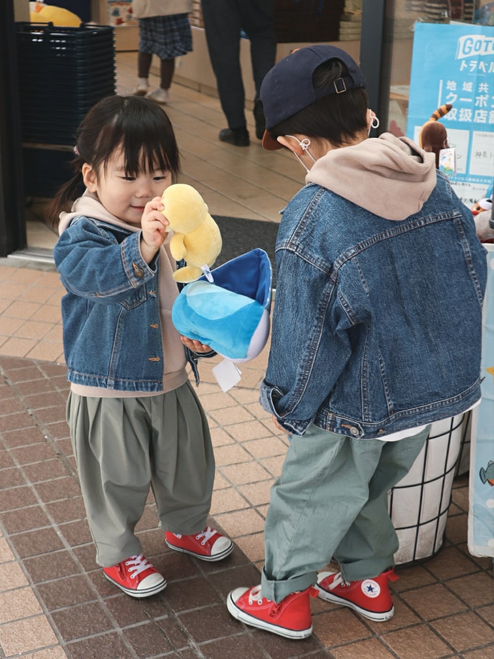 ベージュ系のパーカー、グリーン系のその他パンツ、レッド系のスニーカーを着用したキッズの春コーディネートの3枚目の写真