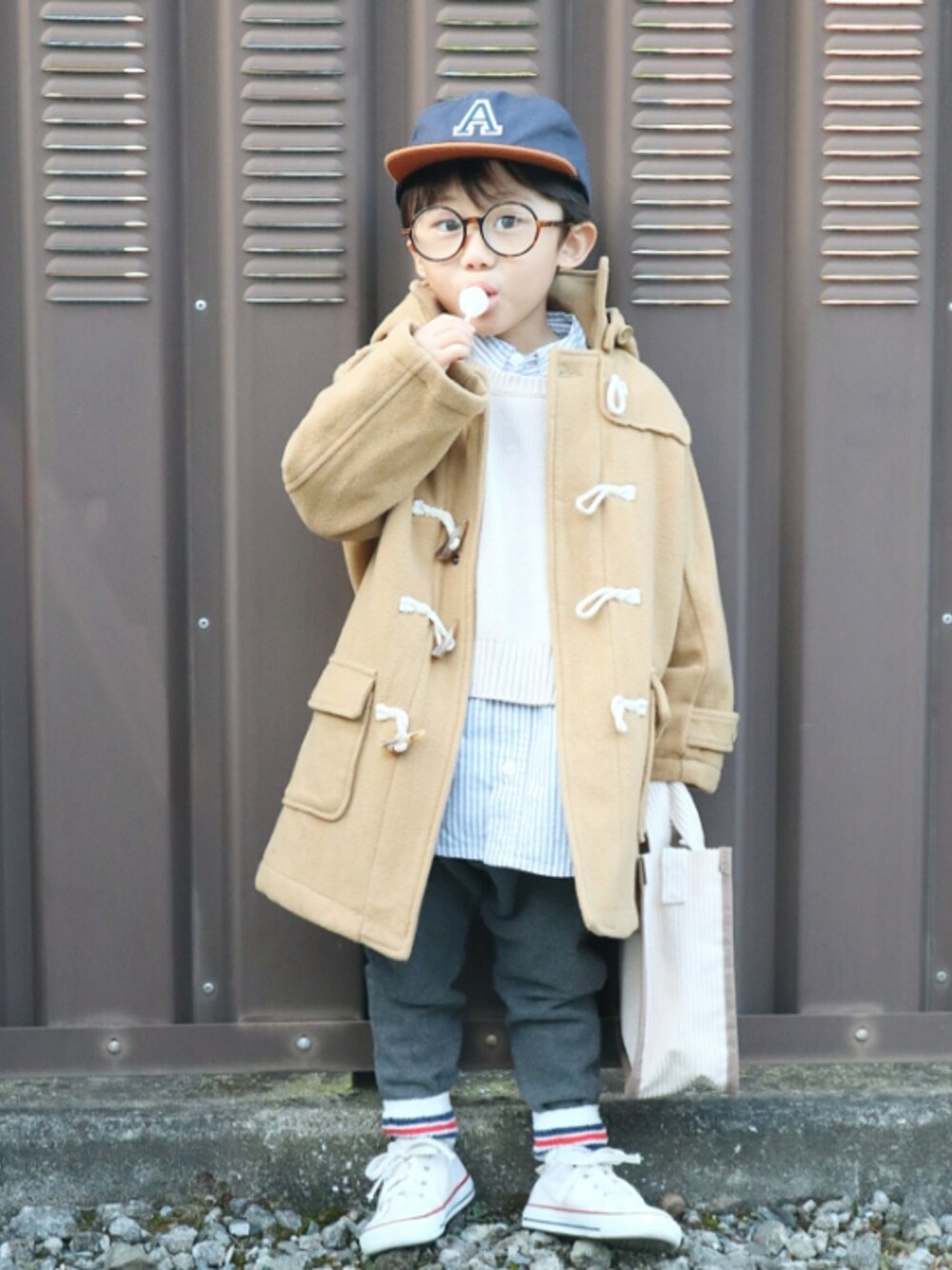 ベージュ系のニット/セーター、ブルー系のシャツ/ブラウス、グレー系のスウェットパンツを着用したキッズの冬コーディネートの1枚目の写真