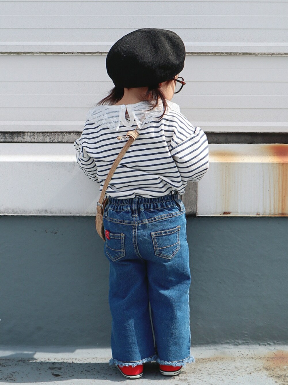 ブルー系のTシャツ/カットソー、ベージュ系のショルダーバッグ、ブルー系のデニムパンツを着用したキッズの春コーディネートの2枚目の写真