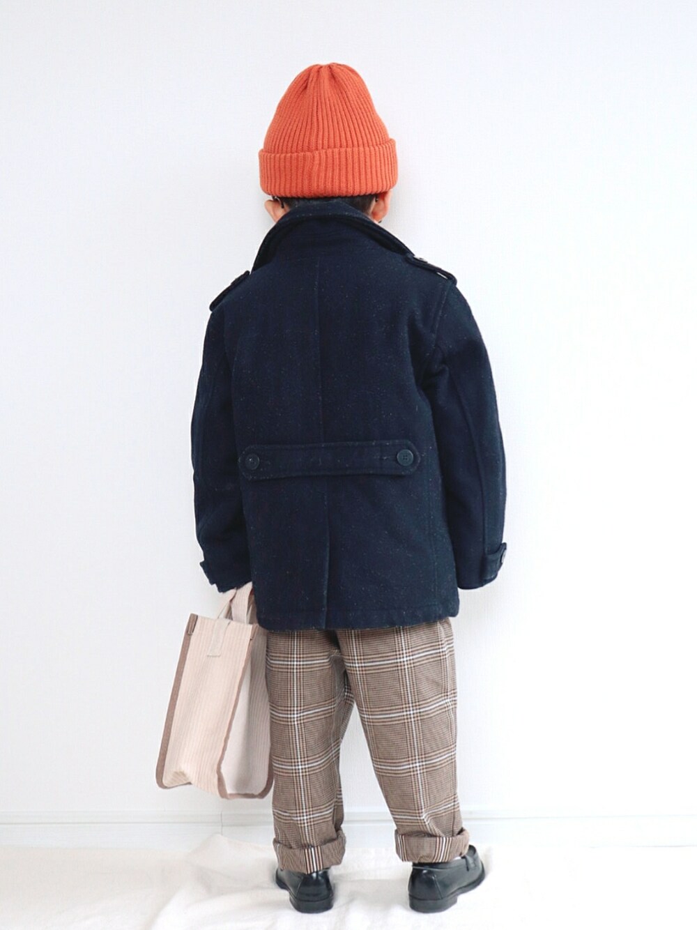 ブルー系のピーコート、ホワイト系のニット/セーター、ブラウン系のパンツを着用したキッズの冬コーディネートの2枚目の写真