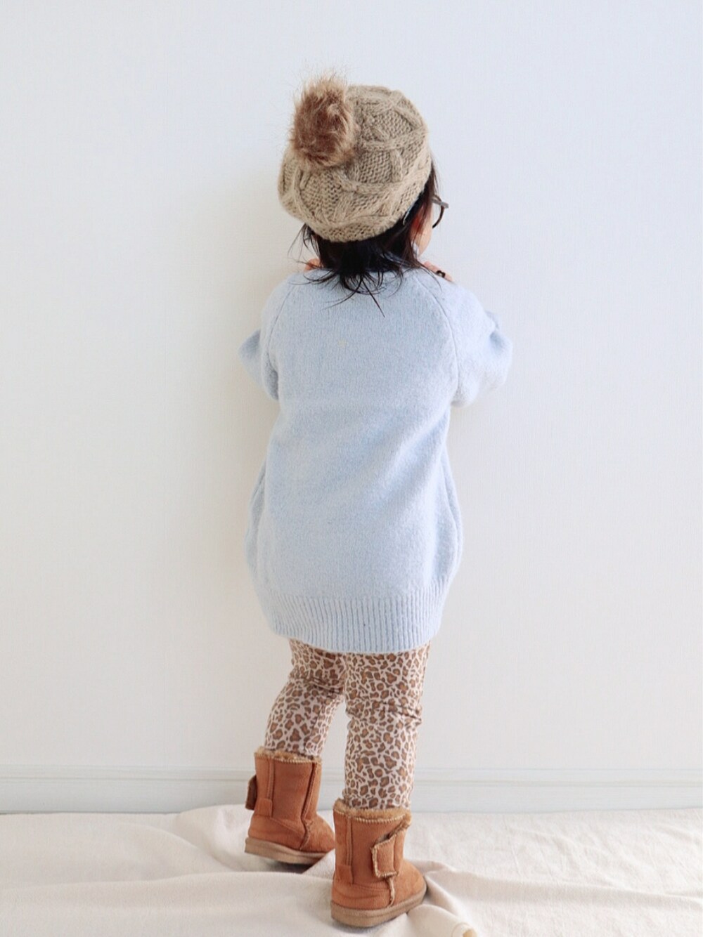 ブルー系のニット/セーター、ブラウン系のブーツ、ベージュ系のハンチング/ベレー帽を着用したキッズの冬コーディネートの3枚目の写真