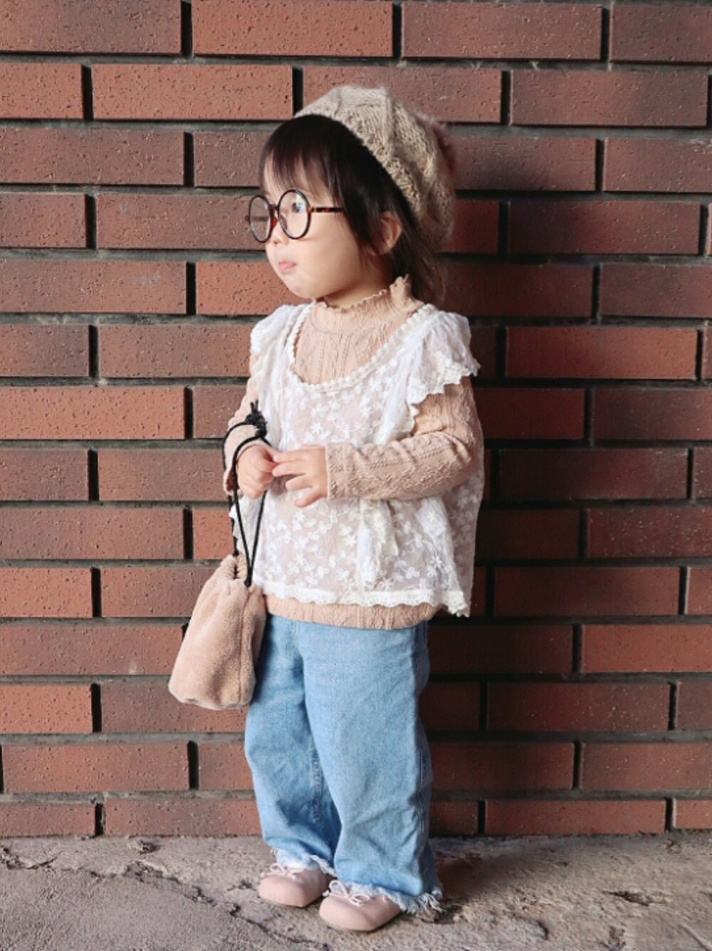 ホワイト系のベスト、ブルー系のデニムパンツ、ピンク系のバレエシューズを着用したキッズの秋コーディネートの1枚目の写真