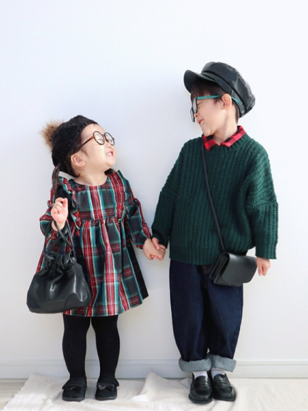 グリーン系のニット/セーター、ブルー系のデニムパンツ、ブラック系のローファーを着用したキッズの冬コーディネートの1枚目の写真