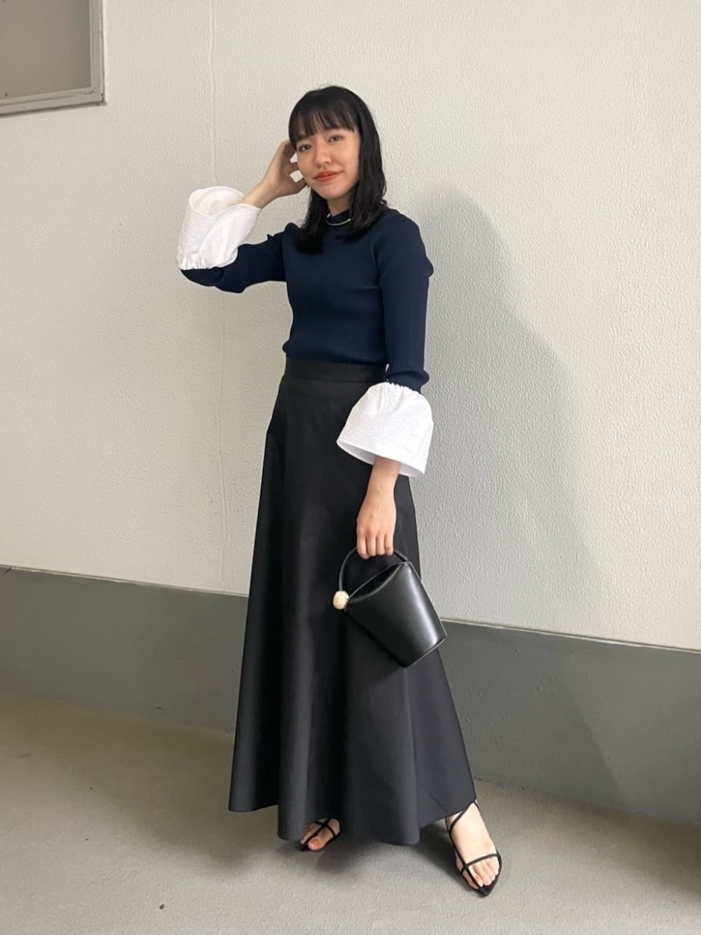ブラック系のスカート、ブルー系のニット/セーターを着用したレディースの夏コーディネートの1枚目の写真