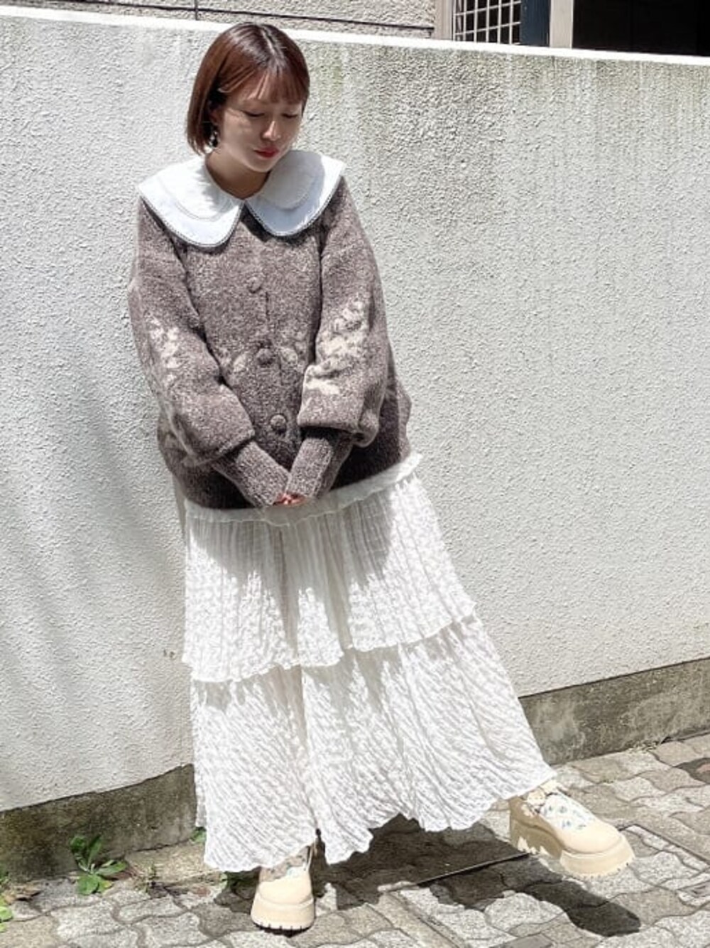 ブラウン系のカーディガン/ボレロ、ホワイト系のシャツ/ブラウス、ホワイト系のローファーを着用したレディースの夏コーディネートの1枚目の写真