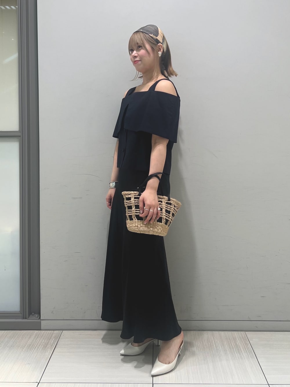ベージュ系のかごバッグ、ブラック系のシャツ/ブラウス、ブラック系のスカートを着用したレディースの春コーディネートの1枚目の写真