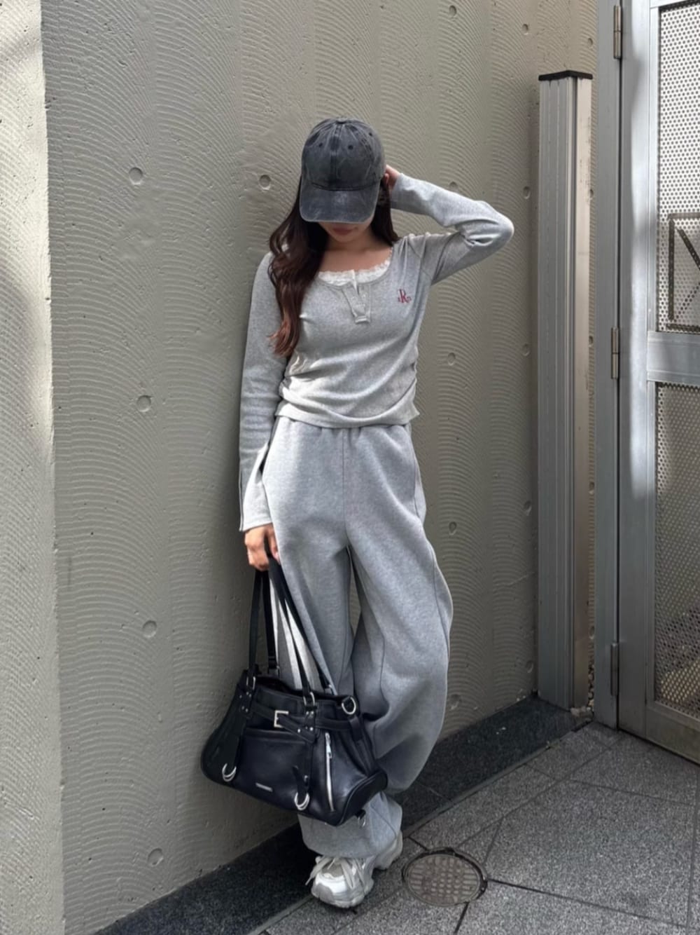 グレー系のTシャツ/カットソー、ブラック系のショルダーバッグを着用したレディースの春コーディネートの1枚目の写真