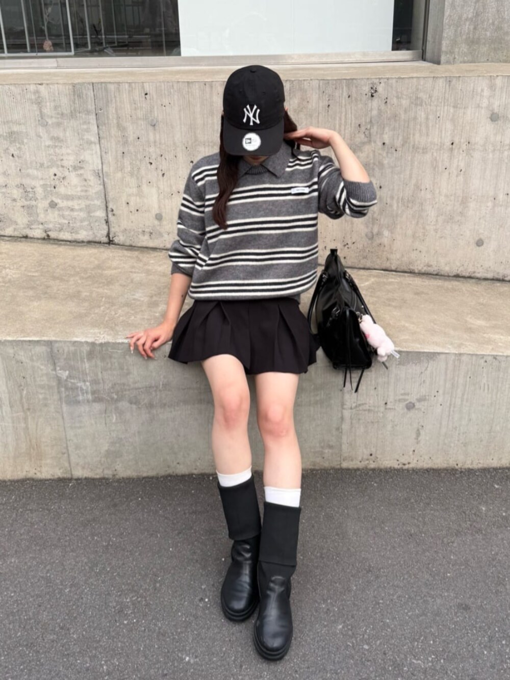 グレー系のニット/セーター、ブラック系のスカートを着用したレディースの秋コーディネートの1枚目の写真