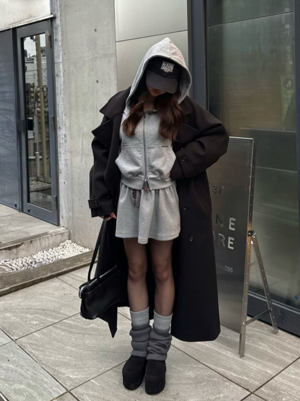 ブラック系のその他アウター、グレー系のパーカー、グレー系のスカートを着用したレディースの冬コーディネートの1枚目の写真