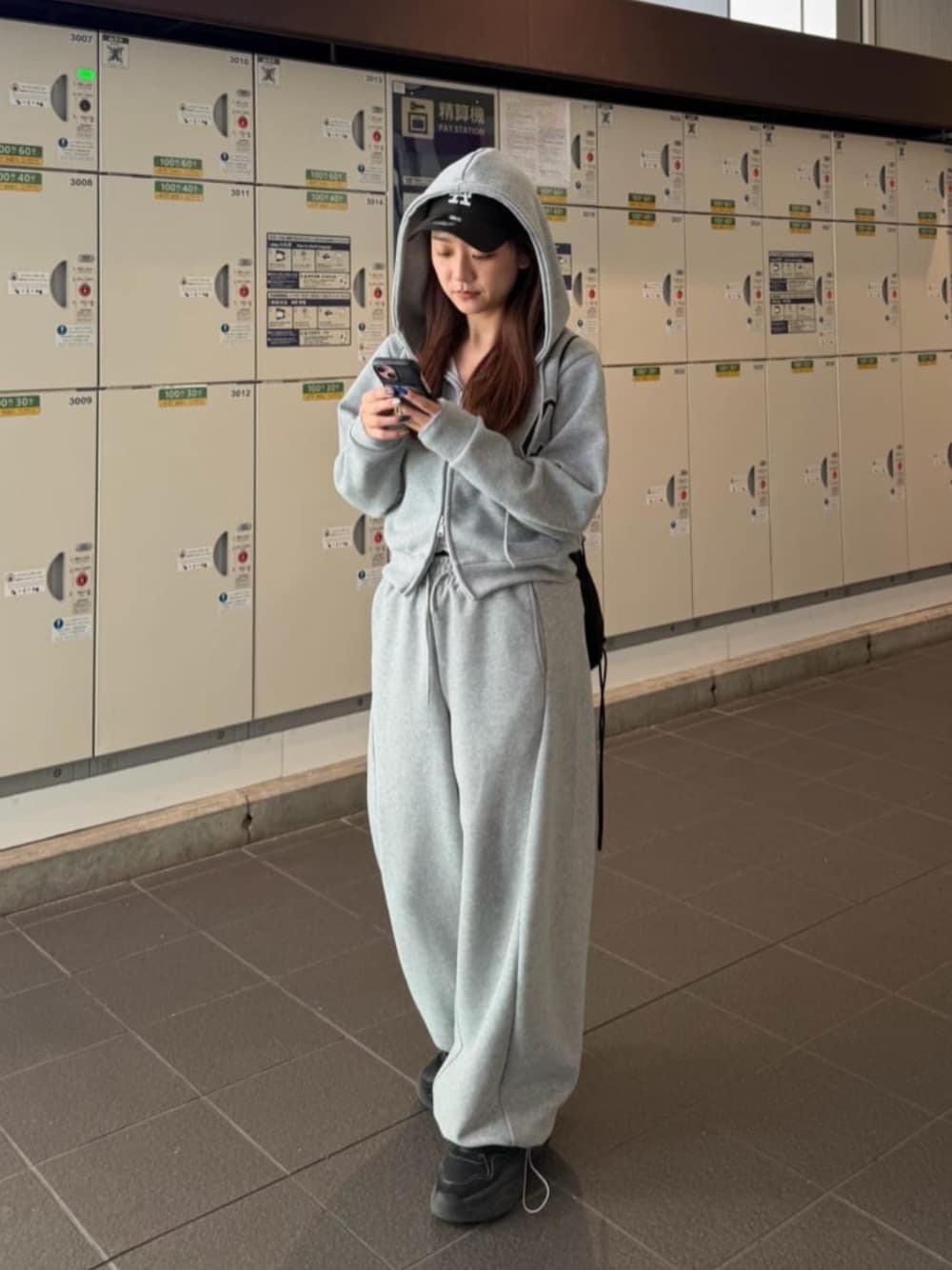 グレー系のスウェットパンツ、グレー系のパーカーを着用したレディースの冬コーディネートの1枚目の写真