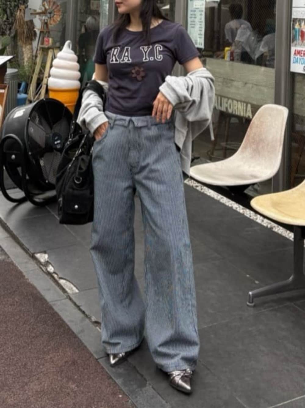 シルバー系のサンダル、ブルー系のデニムパンツ、グレー系のパーカーを着用したレディースの夏コーディネートの1枚目の写真