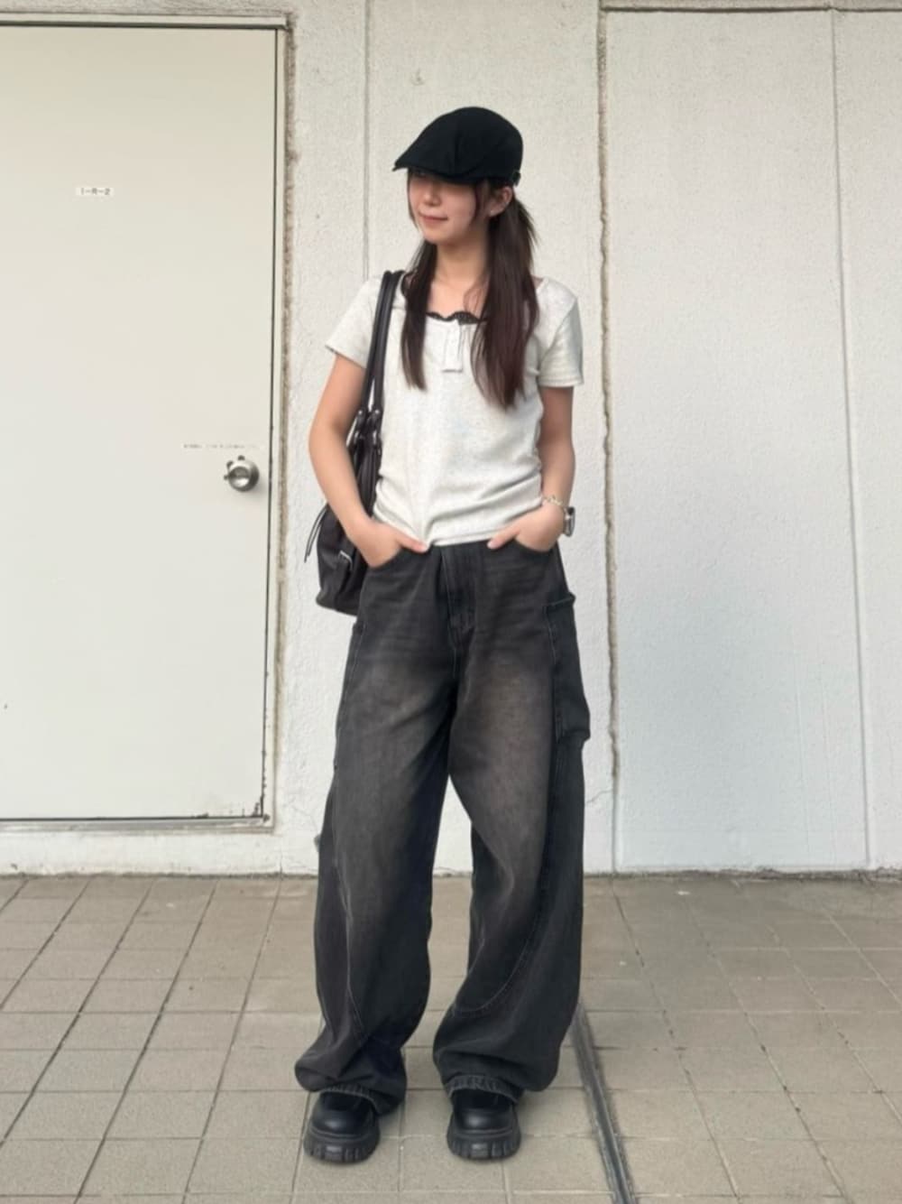 ブラック系のデニムパンツ、ホワイト系のTシャツ/カットソーを着用したレディースの春コーディネートの1枚目の写真