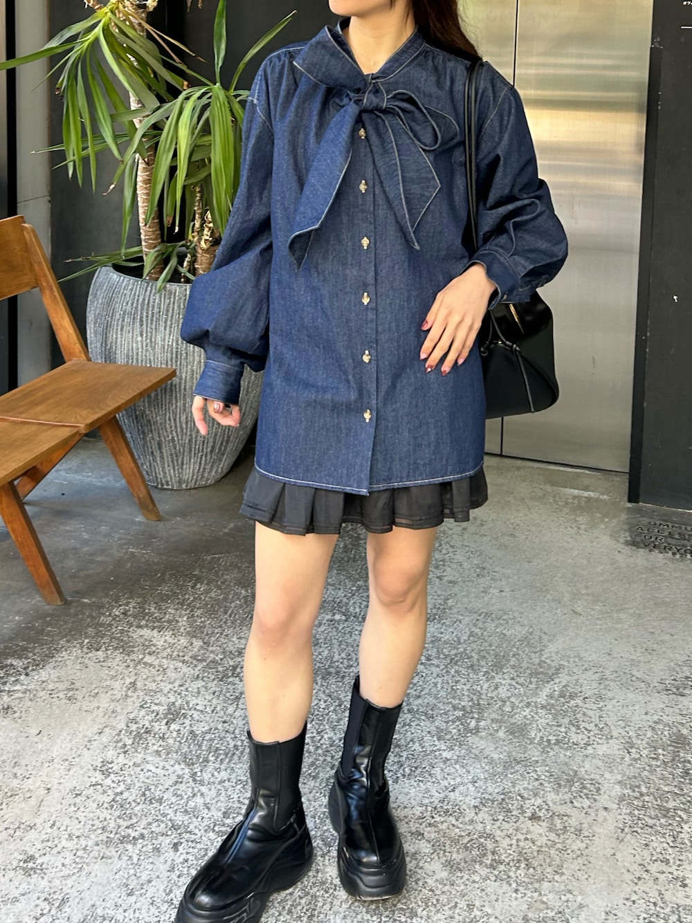ブルー系のシャツ/ブラウス、ブラック系のスカートを着用したレディースの秋コーディネートの1枚目の写真