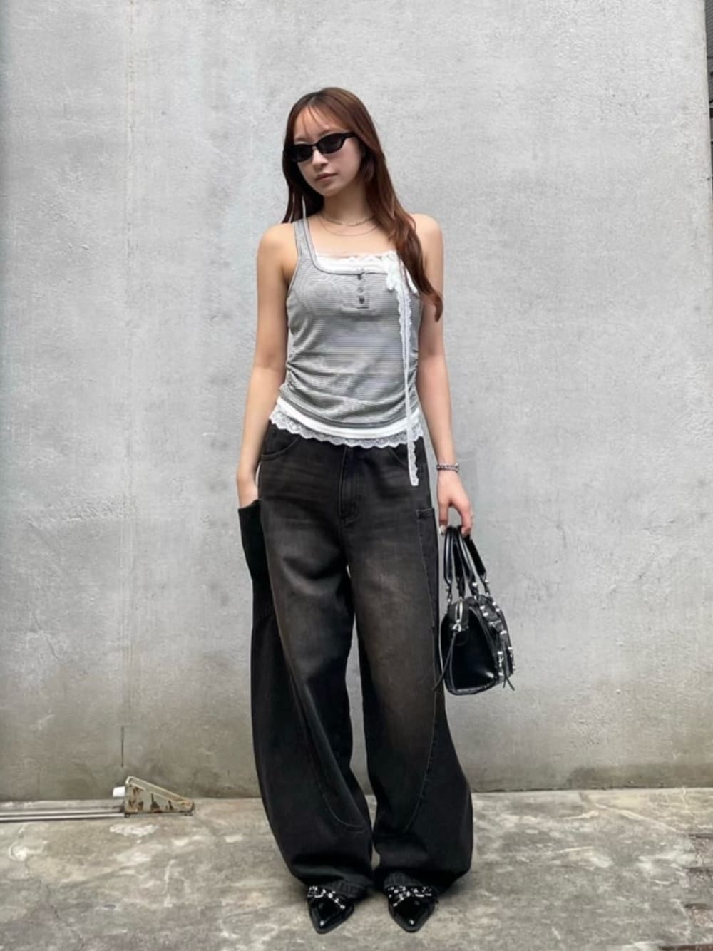 ブラック系のデニムパンツ、ブラック系のその他シューズ、グレー系のTシャツ/カットソーを着用したレディースの夏コーディネートの1枚目の写真