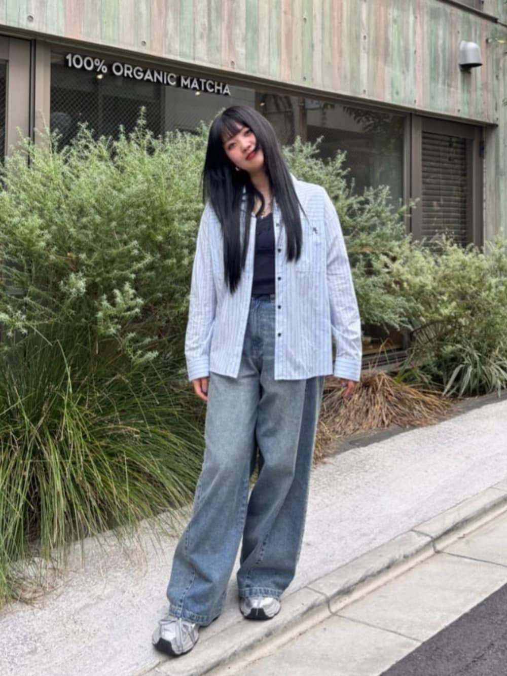 シルバー系のスニーカー、ブルー系のシャツ/ブラウス、ブラック系のキャミソールを着用したレディースの秋コーディネートの1枚目の写真