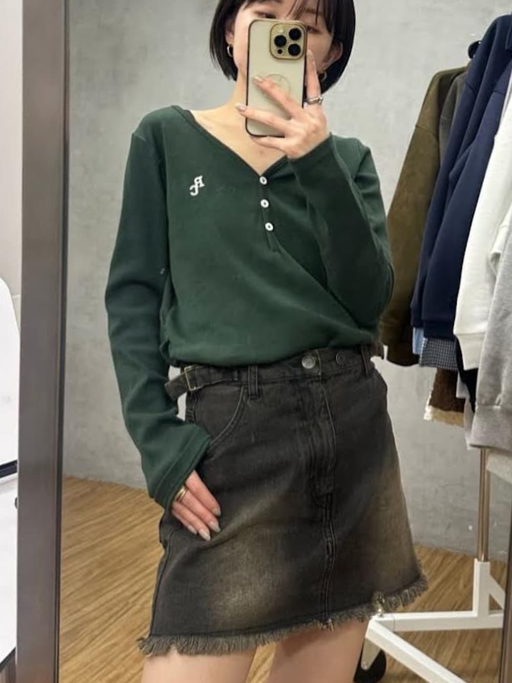 グリーン系のTシャツ/カットソー、ブラウン系のデニムスカートを着用したレディースの冬コーディネートの1枚目の写真