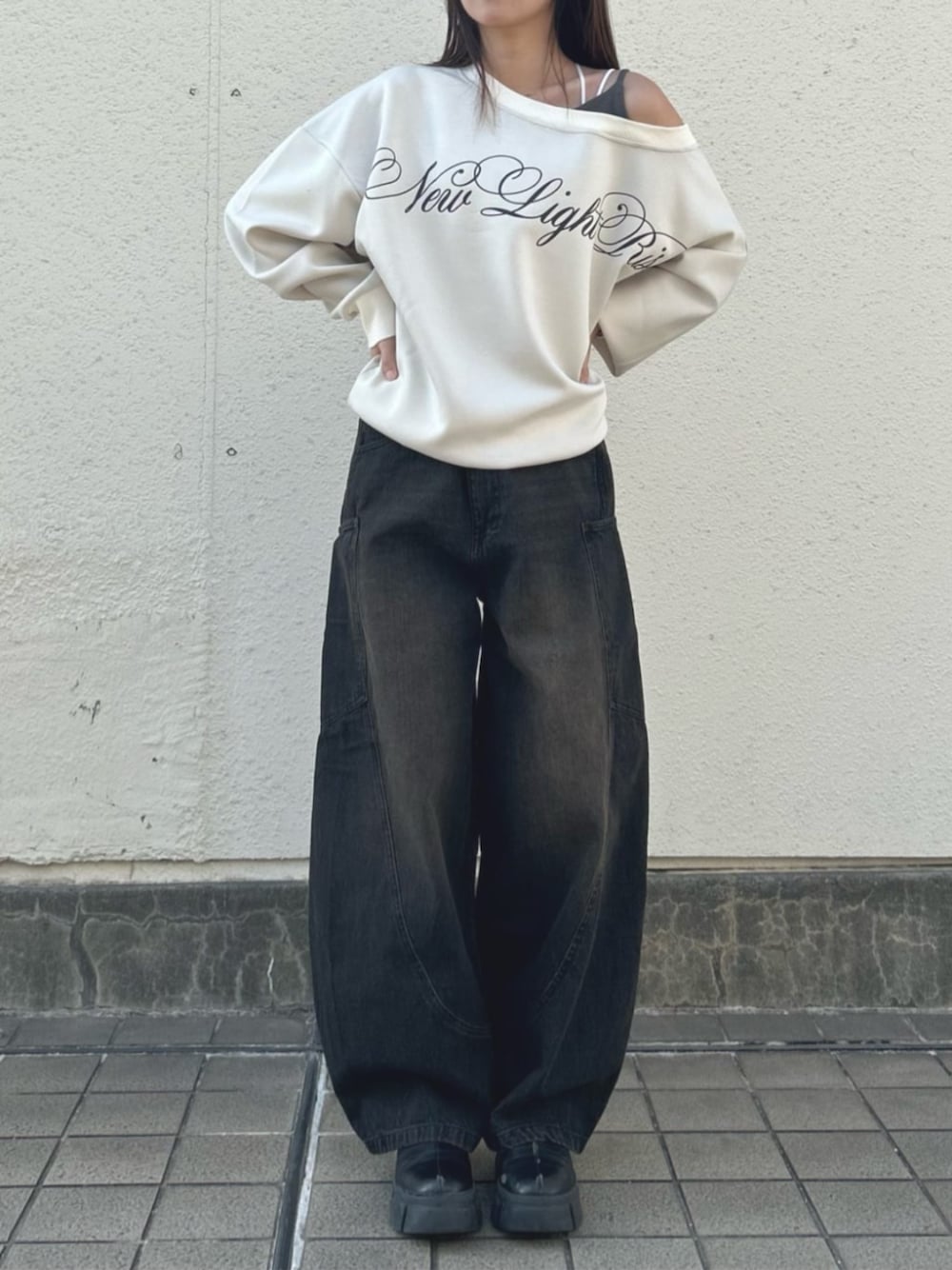 ベージュ系のスウェット、ブラック系のデニムパンツ、ブラック系のデニムパンツを着用したレディースの秋コーディネートの1枚目の写真