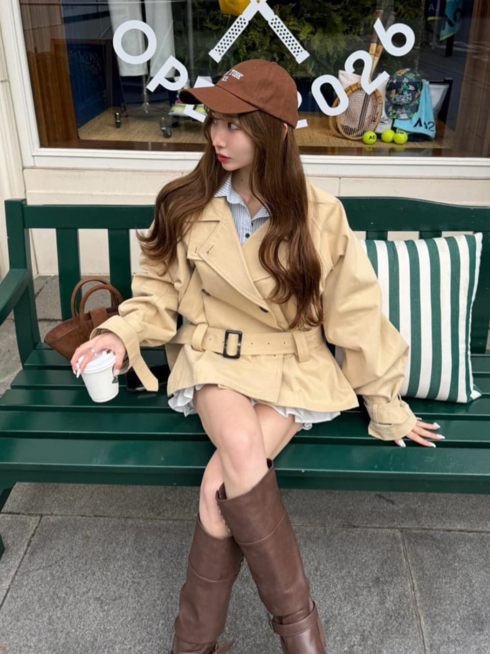 ベージュ系のトレンチコートを着用したレディースの冬コーディネートの1枚目の写真