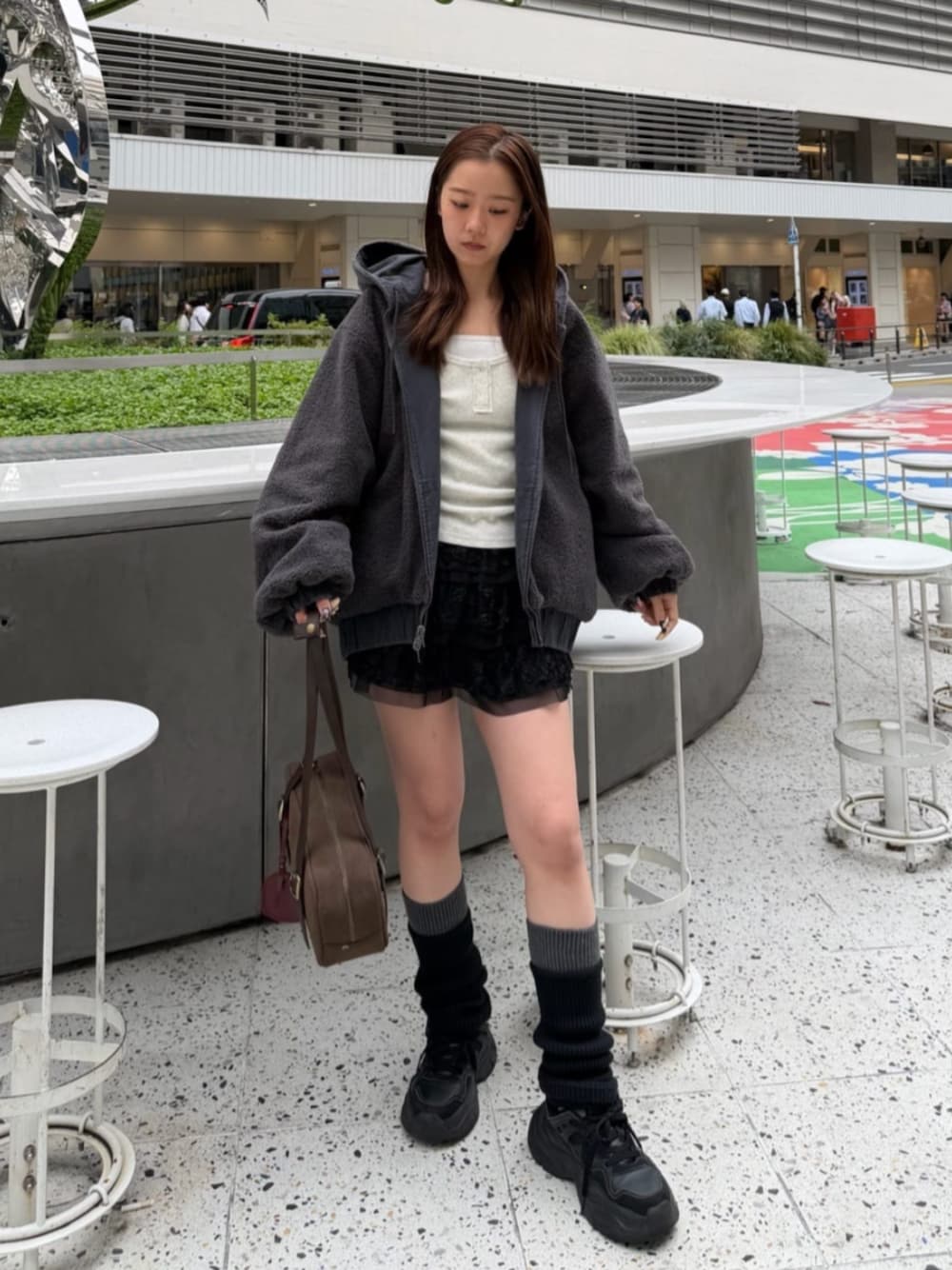 ブラック系のスカート、グレー系のブルゾン、ホワイト系のTシャツ/カットソーを着用したレディースの秋コーディネートの1枚目の写真