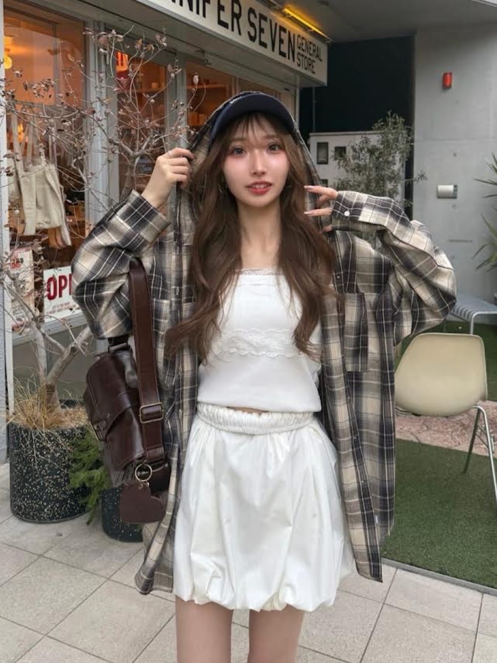 ブラック系のシャツ/ブラウス、ブラウン系のショルダーバッグ、ホワイト系のスカートを着用したレディースの冬コーディネートの1枚目の写真