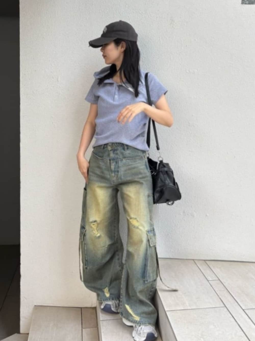 ブルー系のデニムパンツ、グレー系のTシャツ/カットソー、ホワイト系のスニーカーを着用したレディースの春コーディネートの1枚目の写真